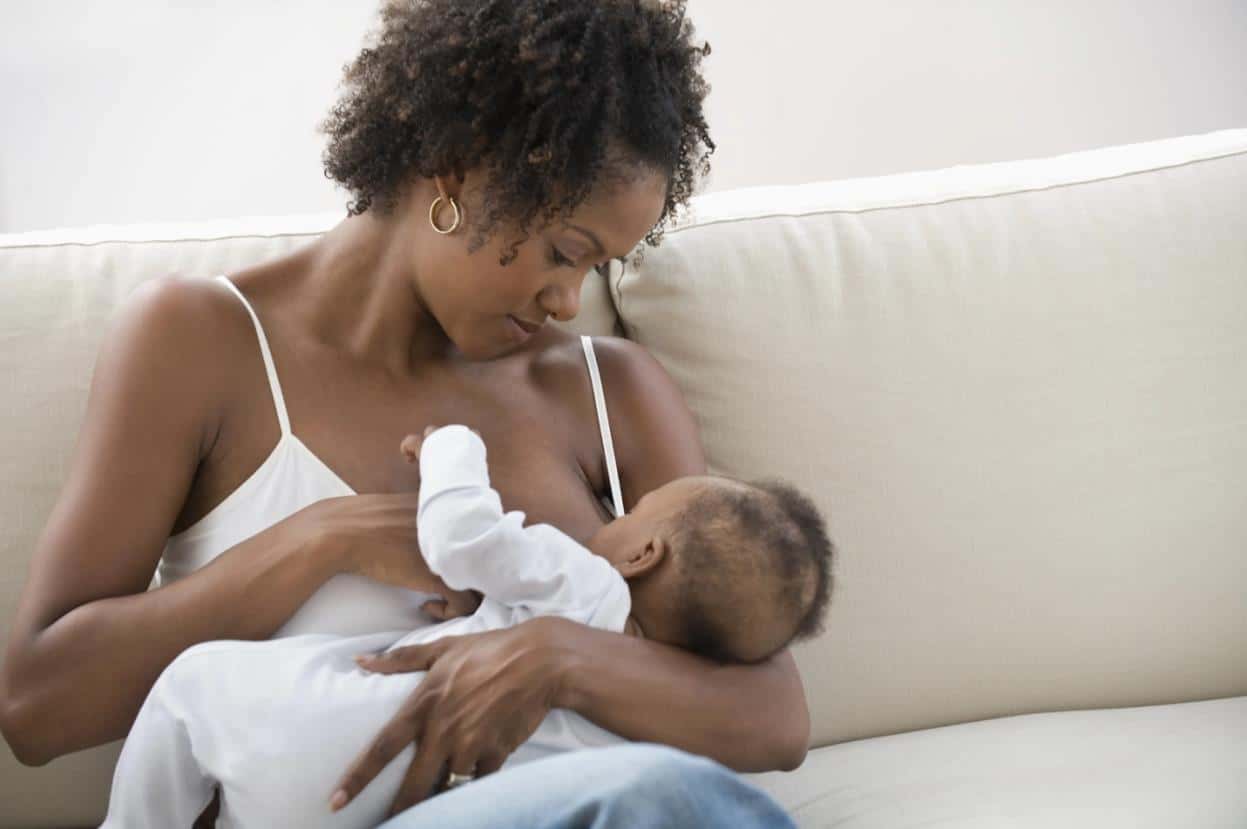 Mother breastfeeding her baby on a couch